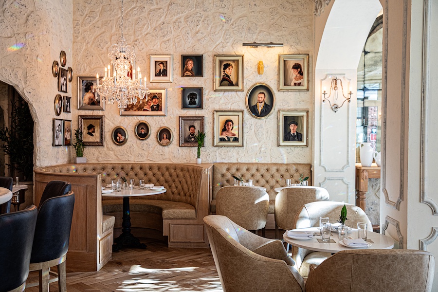La Cave downtown charleston french countryside inspired sipping lounge restaurant portrait gallery wall curved beige banquette