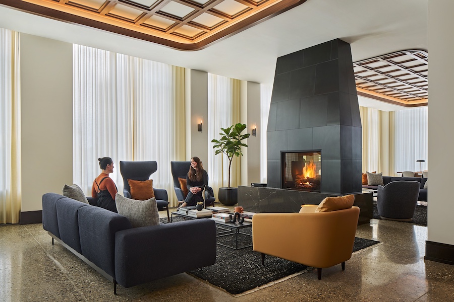 AC Hotel Detroit at the Bonstelle lobby lounge black fireplace brown arm chair coffered ceilings