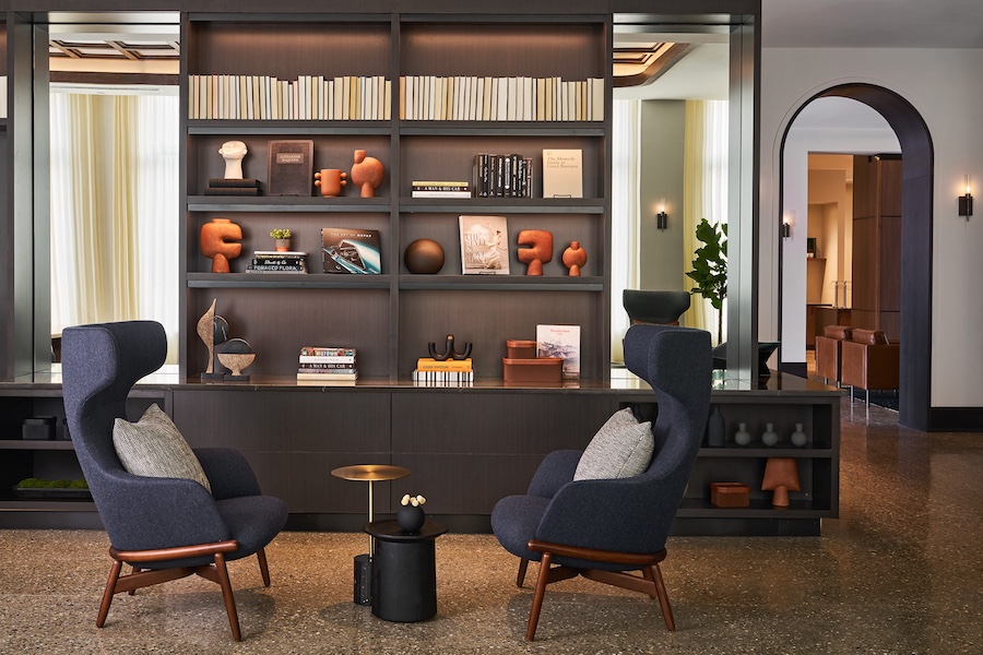 AC Hotel Detroit at the Bonstelle seating blue armchairs built in bookshelves arched doorway