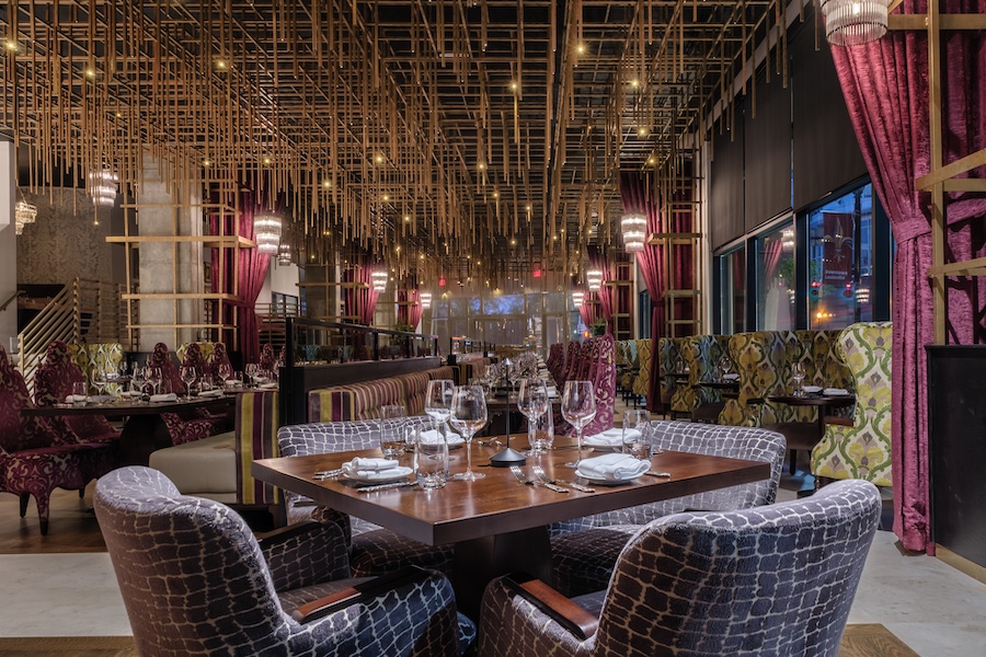 Hotel Bourré Bonne Curio Collection by Hilton kentucky french bourbon design restaurant steakhouse moody floral animal print armchairs purple pink curtains gold metal ceiling installations