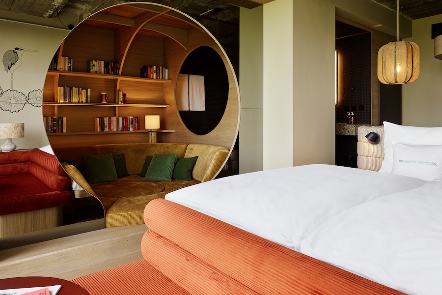 25hours hotel bikini berlin guestrooms bed round circular reading nook mirrored walls red chair indoor plants bed