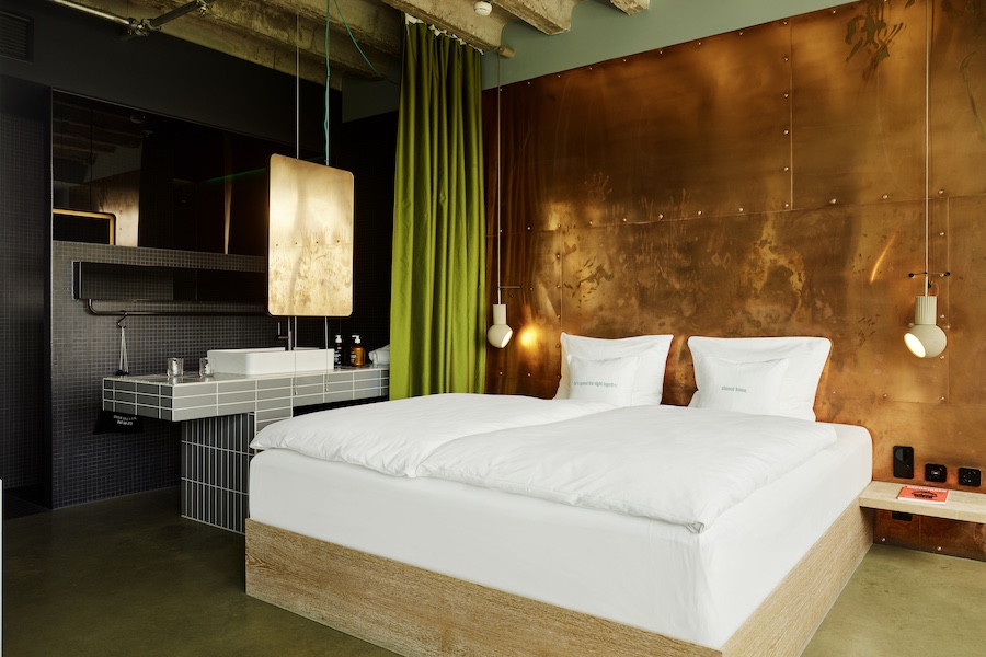 25hours hotel bikini berlin guestrooms bed copper walls green curtains open bathroom gray subway tiles