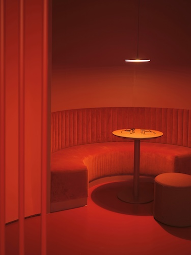elias optics retail spain eyeglass store visual auditory health orange red color drenched round banquette