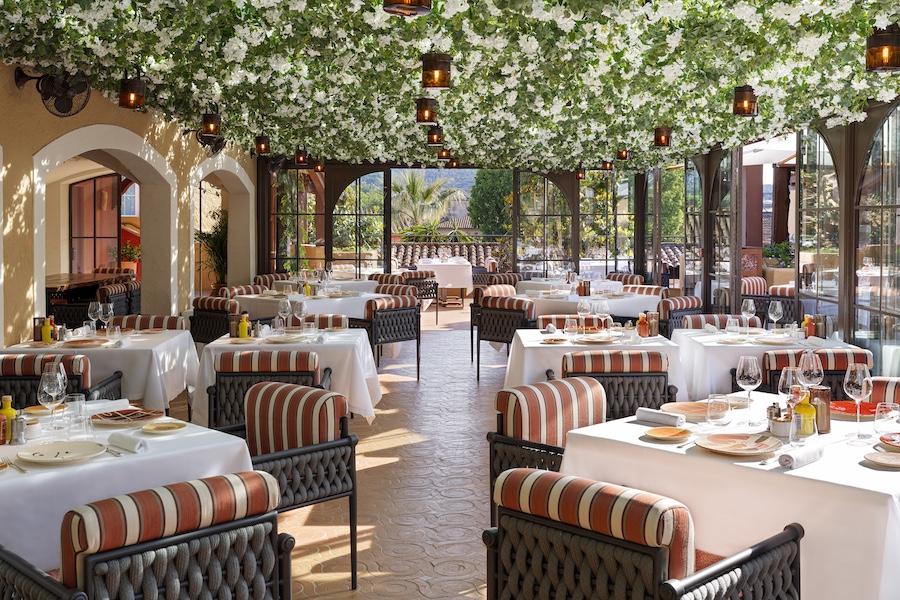 Hotel Byblos Saint-Tropez Il Giardino orange and cream striped chairs white flowers greenery plants ceiling