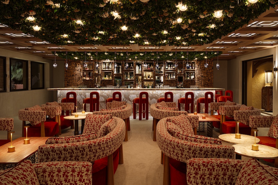 Hotel Byblos Saint-Tropez b lounge red pattern chairs white flowers greenery ceiling plants