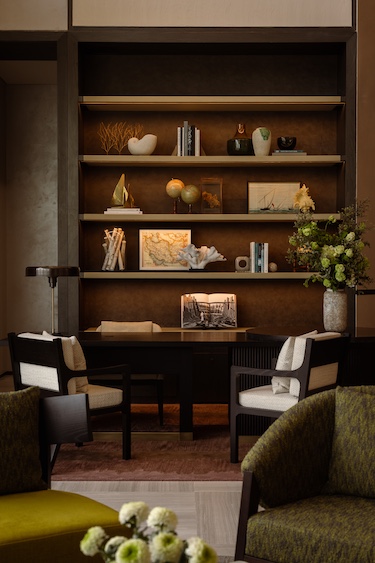 rosewood doha public space wall shelving books ceramics white chairs