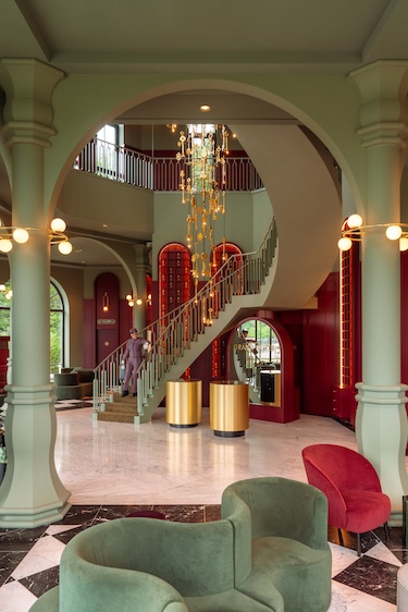 Efteling Grand Hotel the netherlands theme park lobby red walls arched shelving green banquette grand staircase