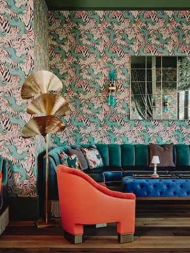 Bar Issi the Thompson Hotel maximalist 1970s mediterranean italian coastal glamor dancing tiger wallcovering wallpaper gold lamp orange arm chair velvet green banquette