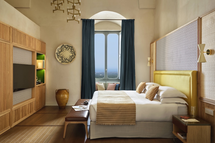 Vista Ostuni puglia italy 14th century palazzo vaulted ceilings guestroom bed yellow headboard teal curtain