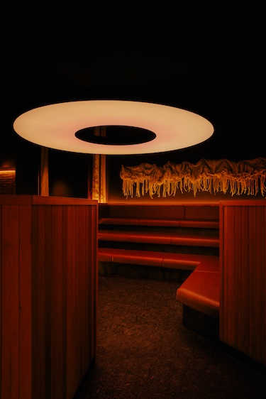 othership brooklyn williamsburg social wellness sauna baths lounge ring light red banquettes