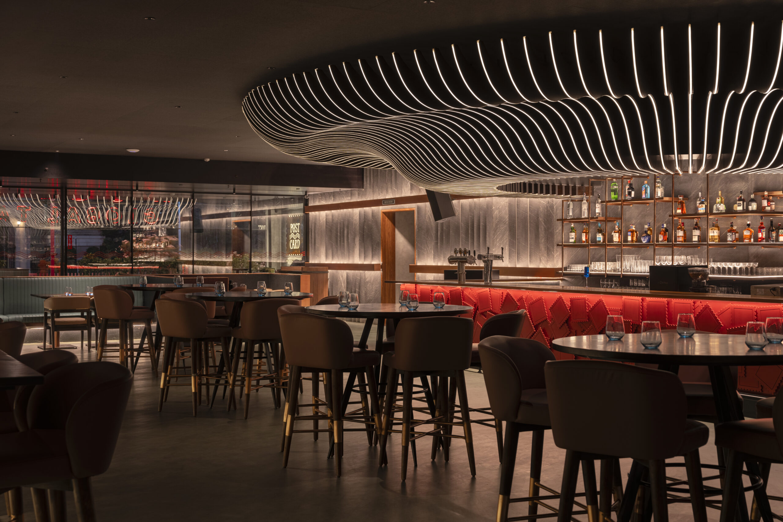 Post Card tapas bar hyderabad india restaurant undulating sculptural light fixture red stamps bar face main dining room copper liquor shelf bar stools