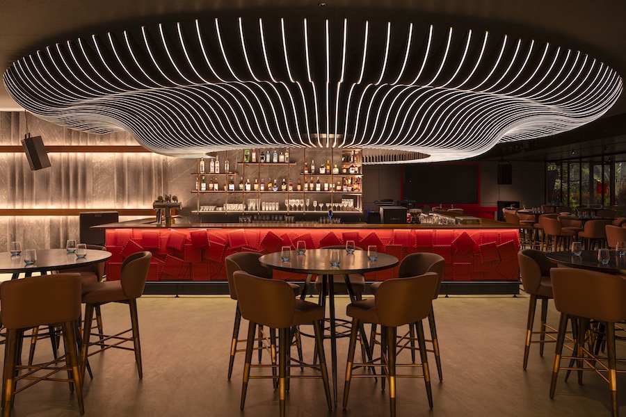 Post Card tapas bar hyderabad india restaurant undulating sculptural light fixture red stamps bar face main dining room copper liquor shelf bar stools