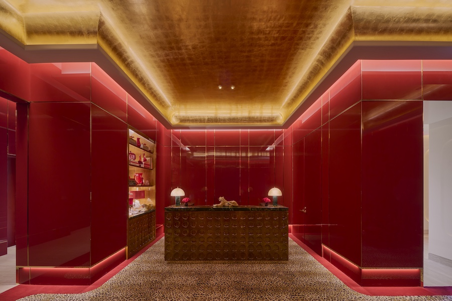 faena new york hotel concierge desk red walls gold gilded ceiling uplighting