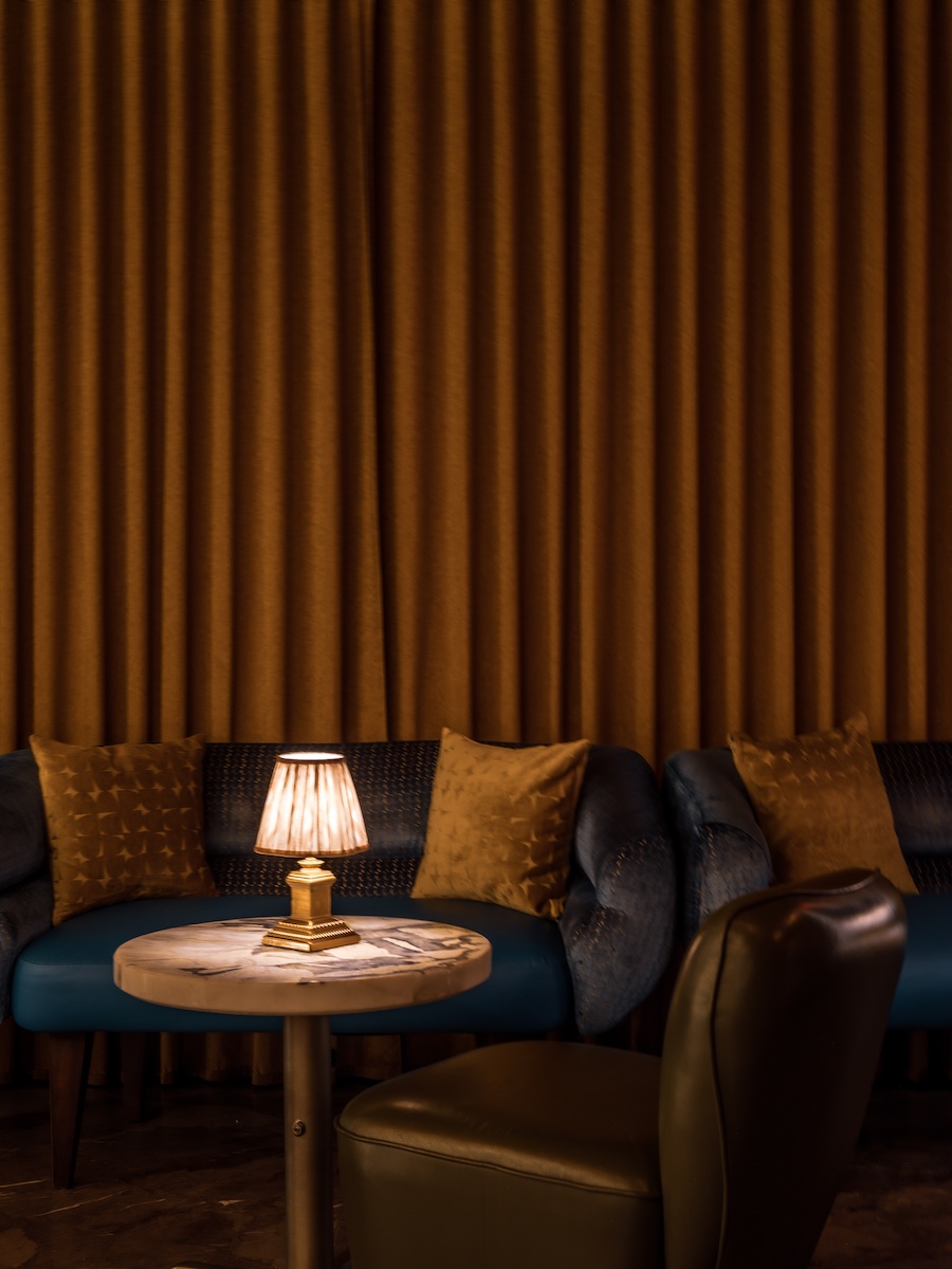 Sirrah new york meatpacking district french maximalism gold drapery blue velvet seating table lamp lounge seating
