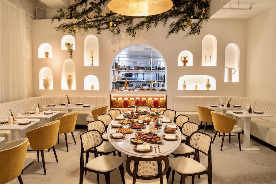 Motek new york manhattan flatiron mediterranean design white interiors yellow accents chairs arched seating niches indoor plants
