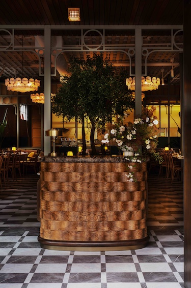 Macarena restaurant silicon valley main dining room statement chandeliers latticed ceiling black and white floor indoor tree plant reception host stand white flowers