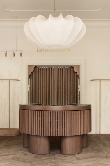 love by the moon kyiv boutique clothing retail store light oak wood white sheer curtains check out reception desk fluted wood millwork white jellyfish light