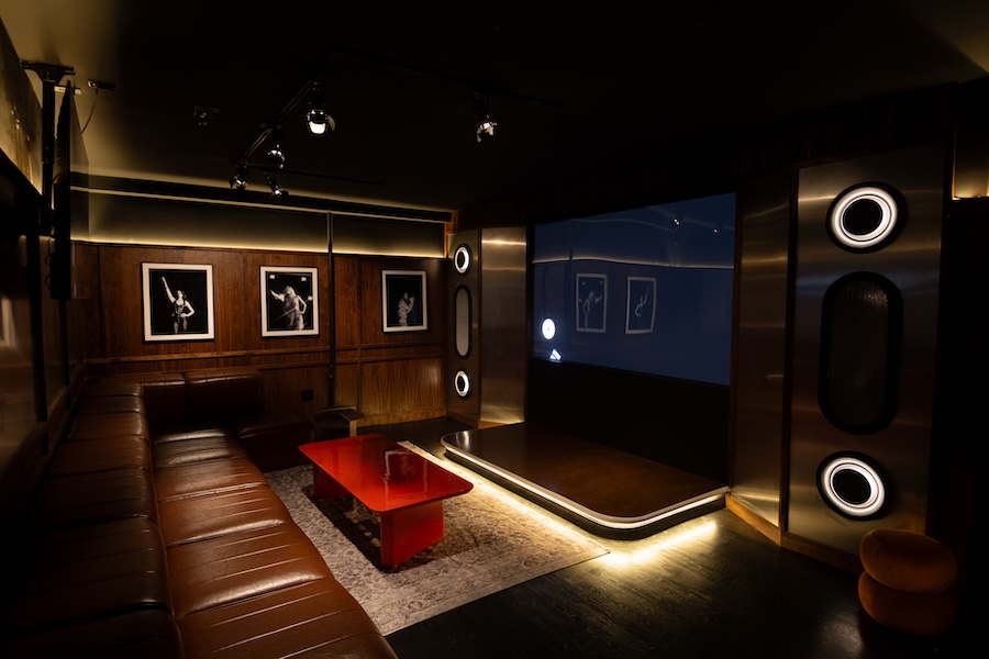 beatbox karaoke venue lounge dark moody brown leather banquette red coffee table wood panel walls