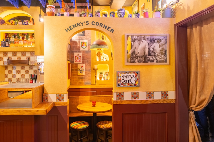 San Patricios jersey city pub cantina mexican irish design yellow walls curtains patterned tables wall art prints papel picado colorful rainbow tissue paper arched doorway private nook banquette