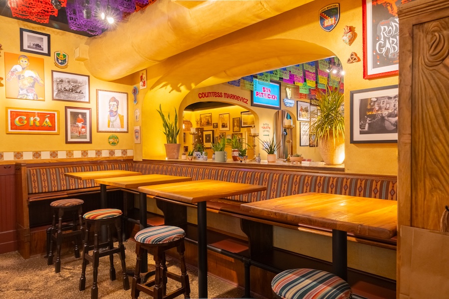 San Patricios jersey city pub cantina mexican irish design yellow walls curtains patterned tables wall art prints papel picado colorful rainbow tissue paper indoor plants