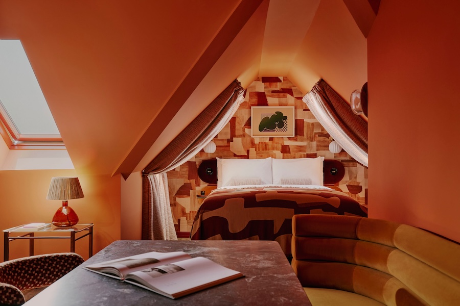 ember locke hotel west london kensington art deco colorful indoor plants guestroom bed canopy orange red brown velvet rolled banquettes